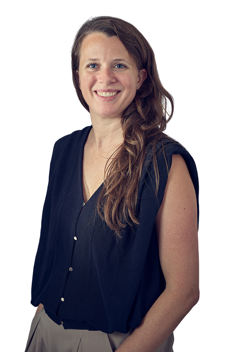 Dr Clarissa Whitmire, a white woman with long, light-brown hair, smiling. Her stance is relaxed and she has her hands in her pockets.