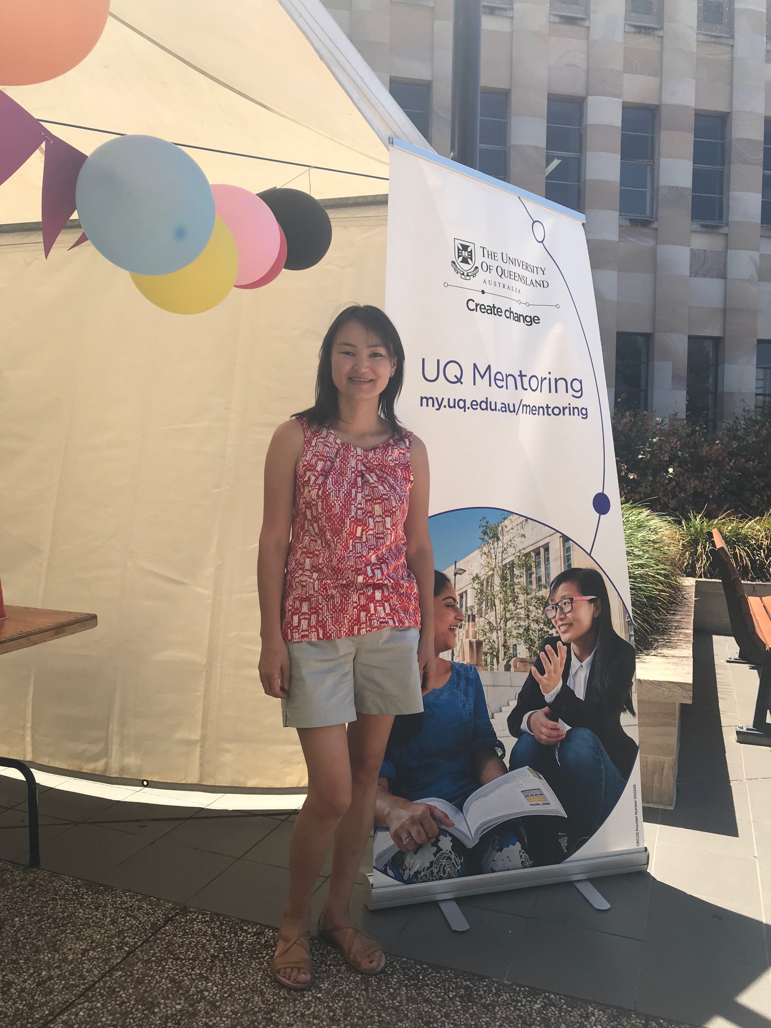 Soyolmaa standing in front of a tent where she is working as a mentor at UQ