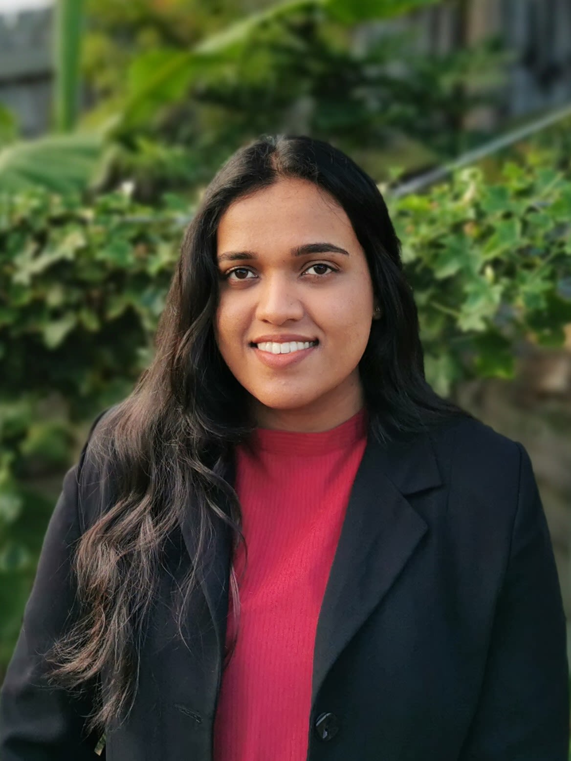 Portrait of Geethu George wearing a red shirt and black jacket