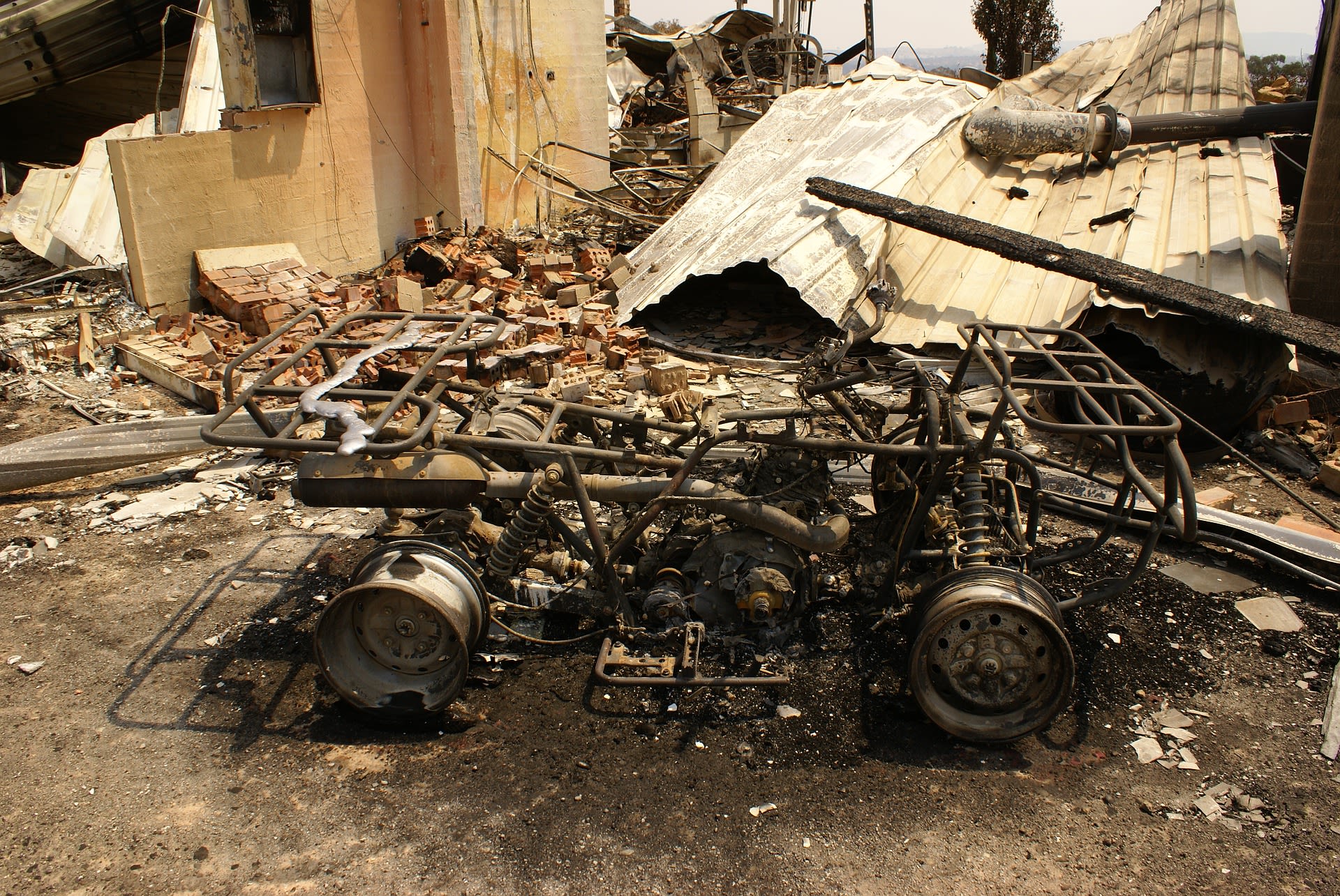 Image of house and car destroyed by bushfires.