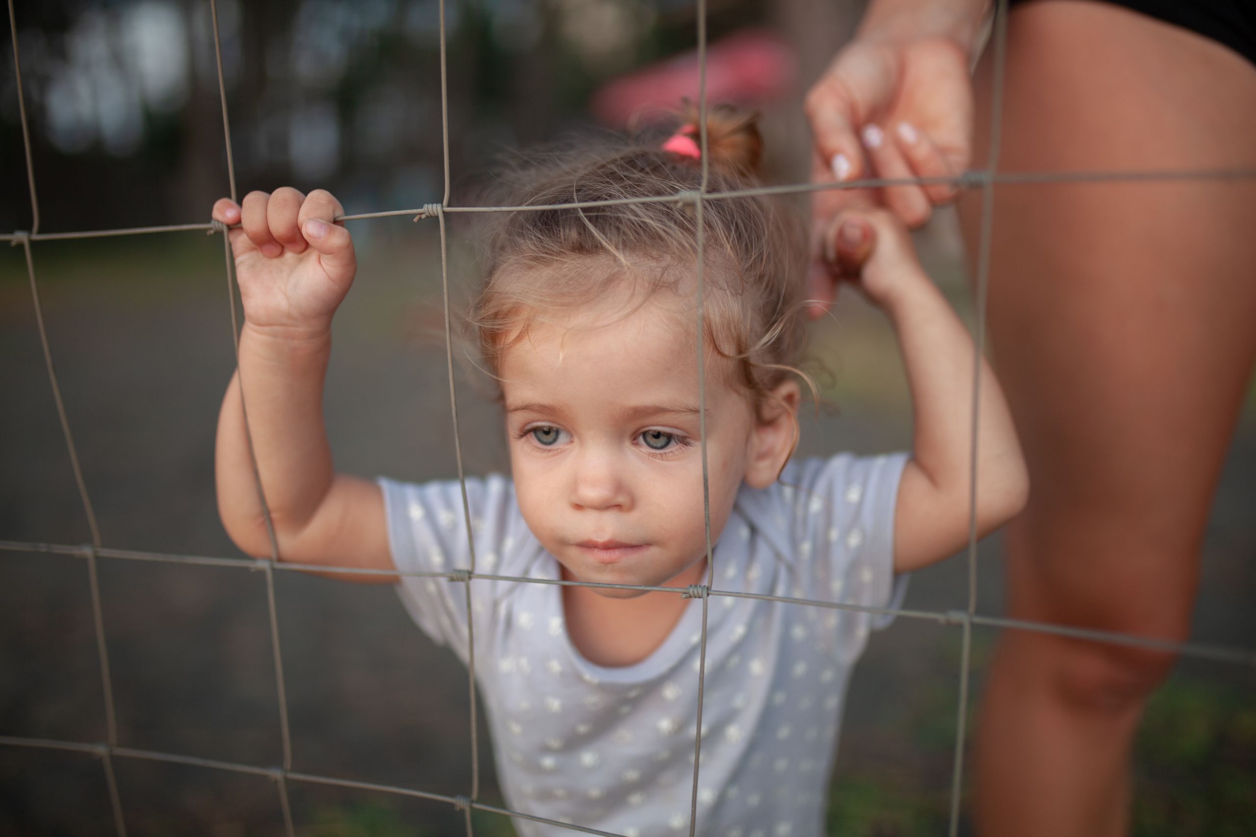 Image of girl behind fence.