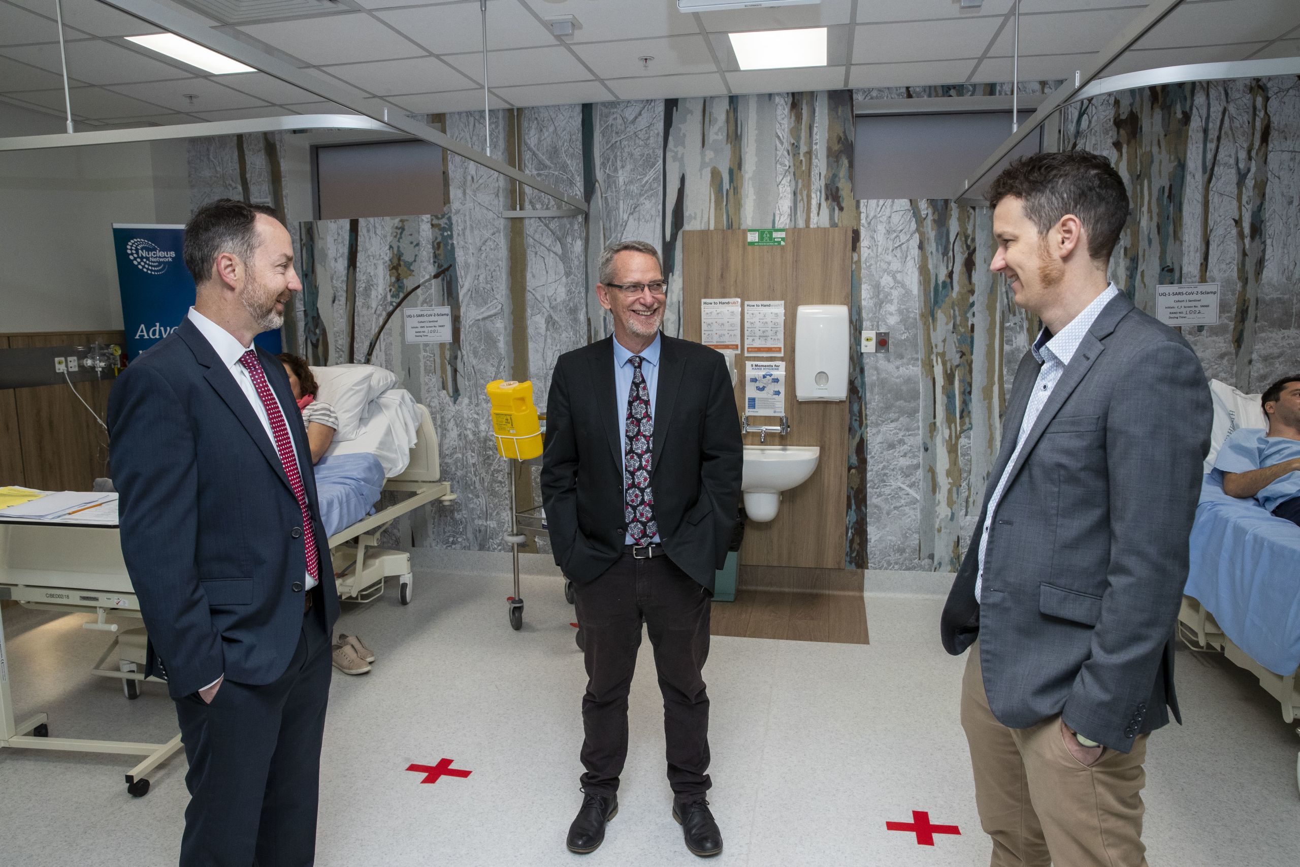 UQ's vaccine researchers, Professors Paul Young, Trent Munro and Associate Professor Keith Chappell stand in front of the first people to be given their COVID-19 vaccine candidate