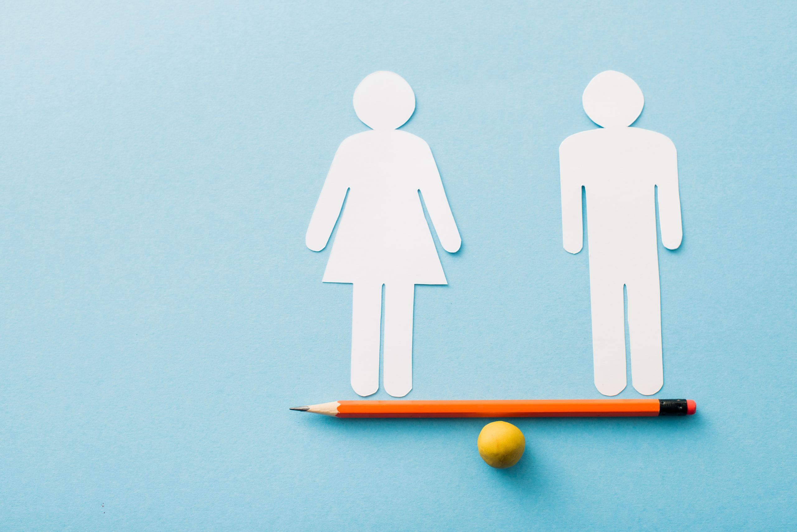 Cut out of a woman and a man balancing on a pencil which is itself balanced on a yellow ball