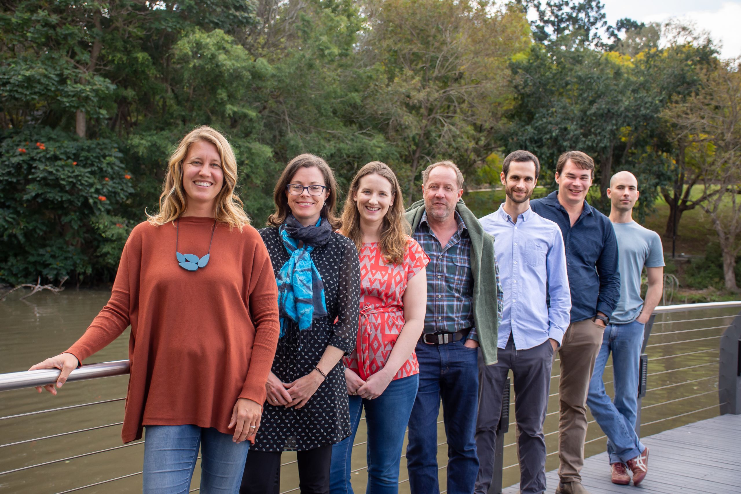 Ridge to Reef Fisheries team standing on a bridge on UQ Lakes with the water behind them.