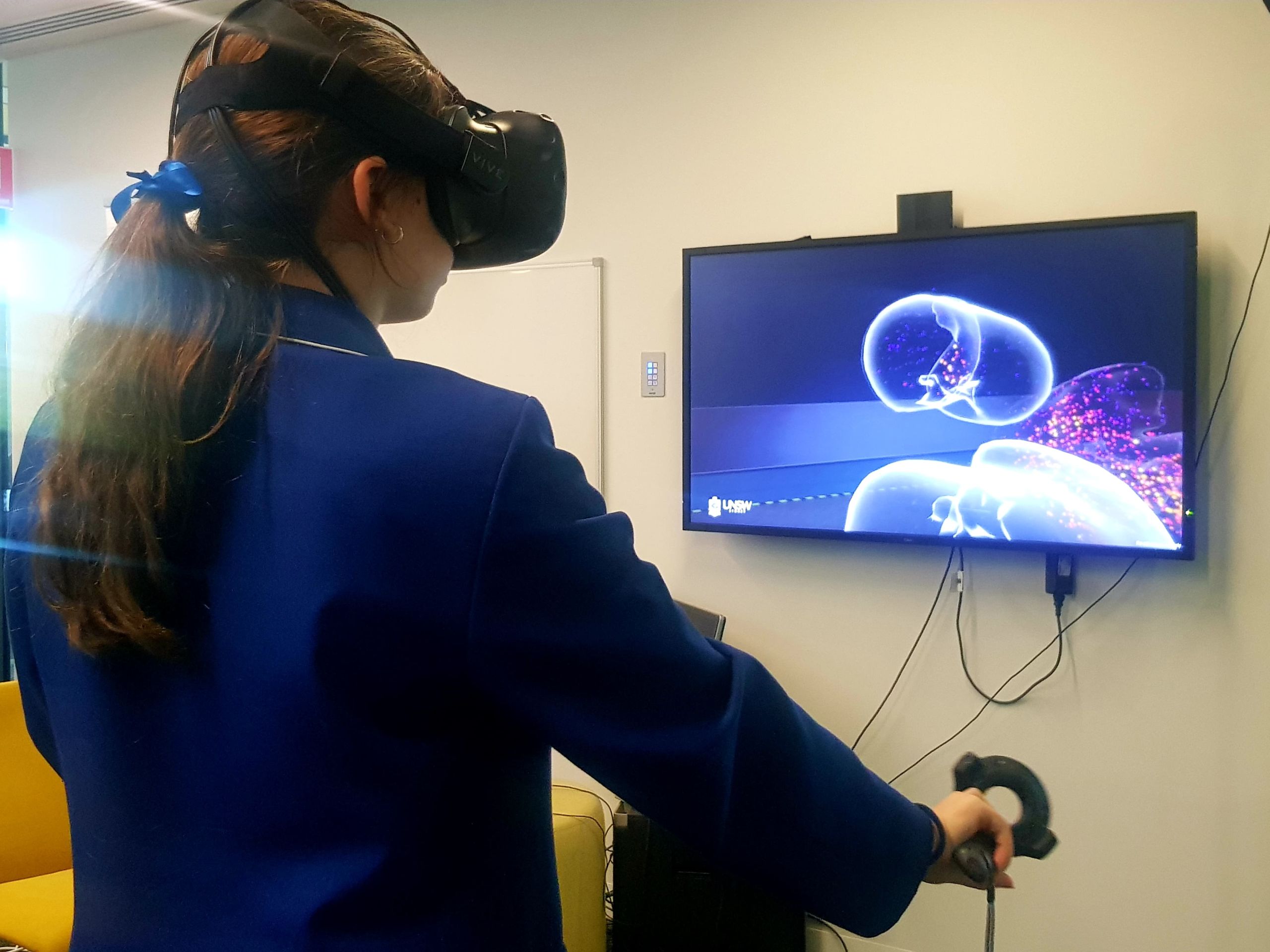 Young student wearing VR glasses and operating a screen in front of her