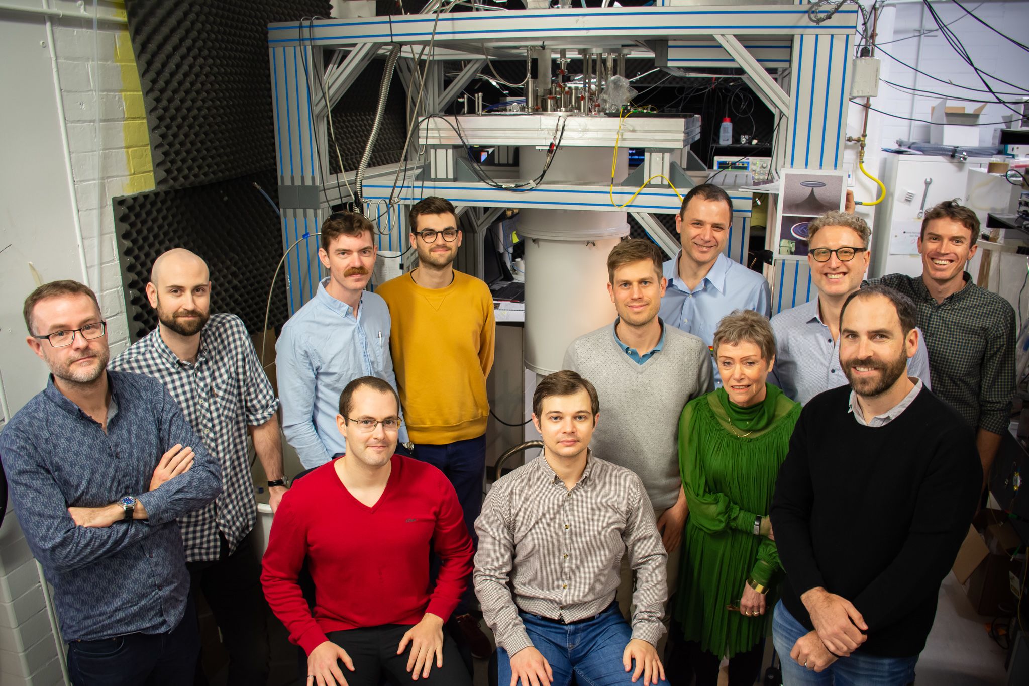 UQ Australian Quantum Vortex team standing in front of an ultra cold refrigerator