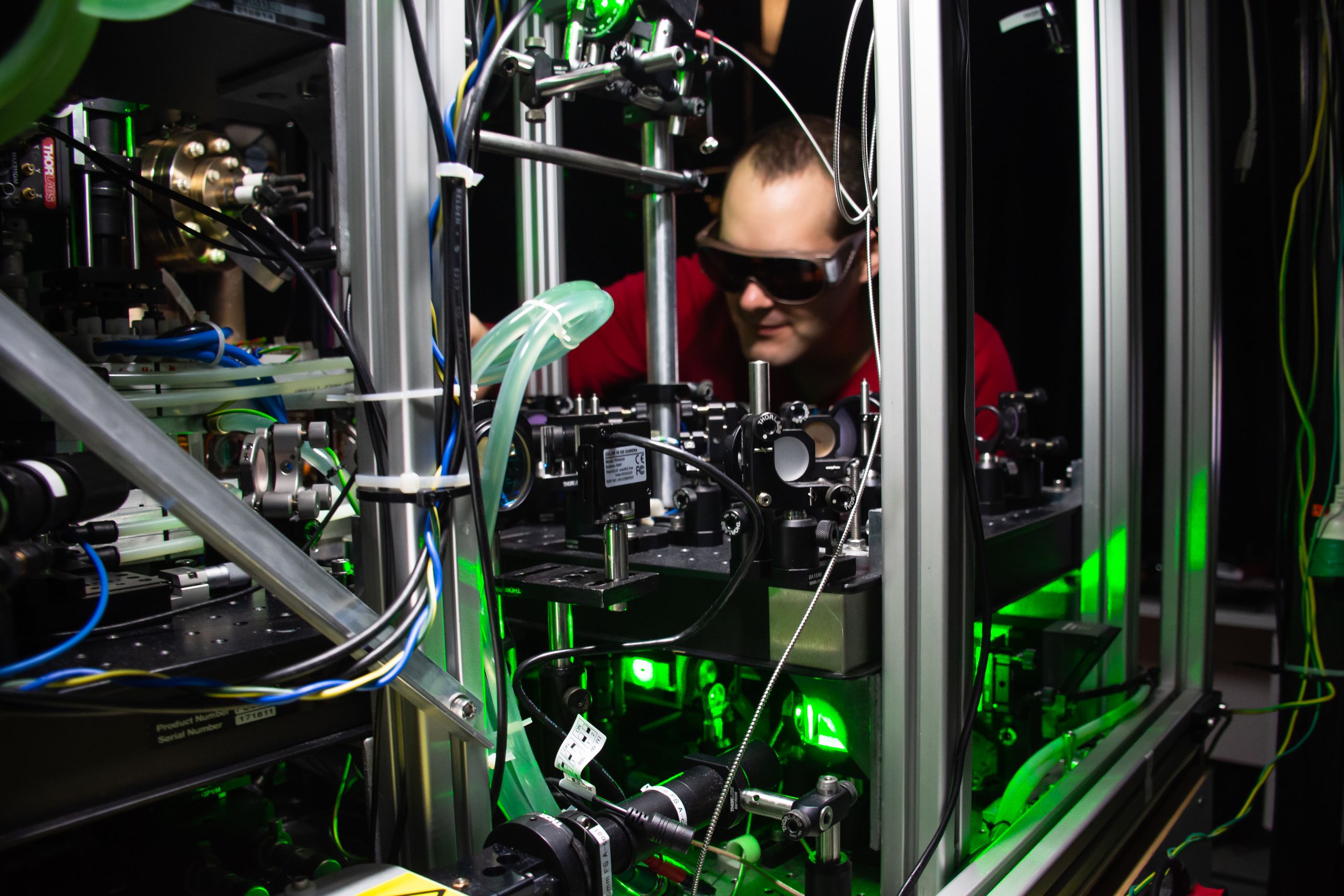 Team member Dr Guillaume Gauthier wearing protective lenses while working on a Bose-Einstein condensate apparatus with green light