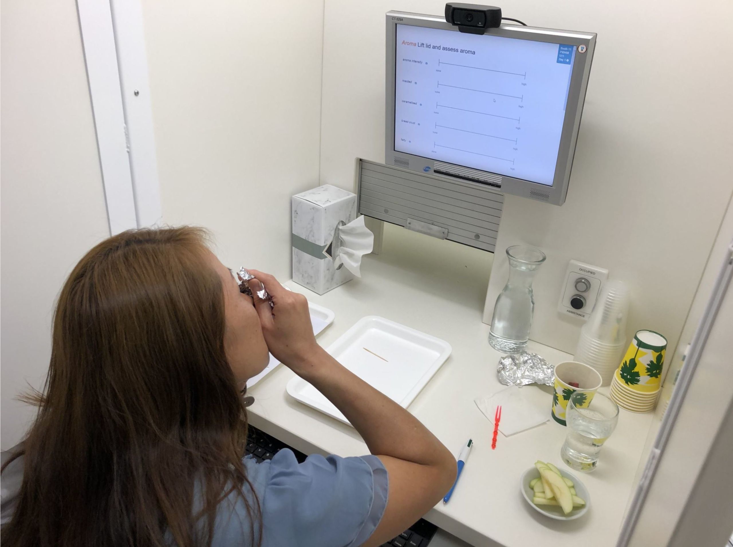 A consumer panellist smells the aroma of the Wagyu beef and submits feedback on a computer.