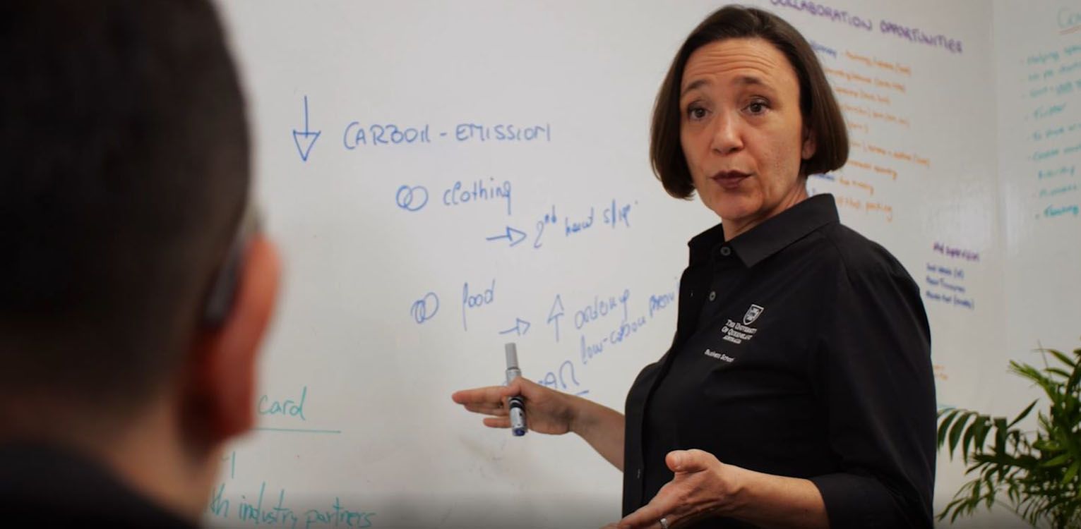 Professor Sara Dolnicar standing at the white board, pen in hand