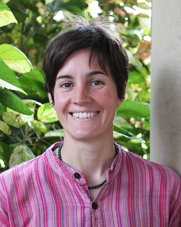 Dr Felicity Meakins standing in front of some foliage.