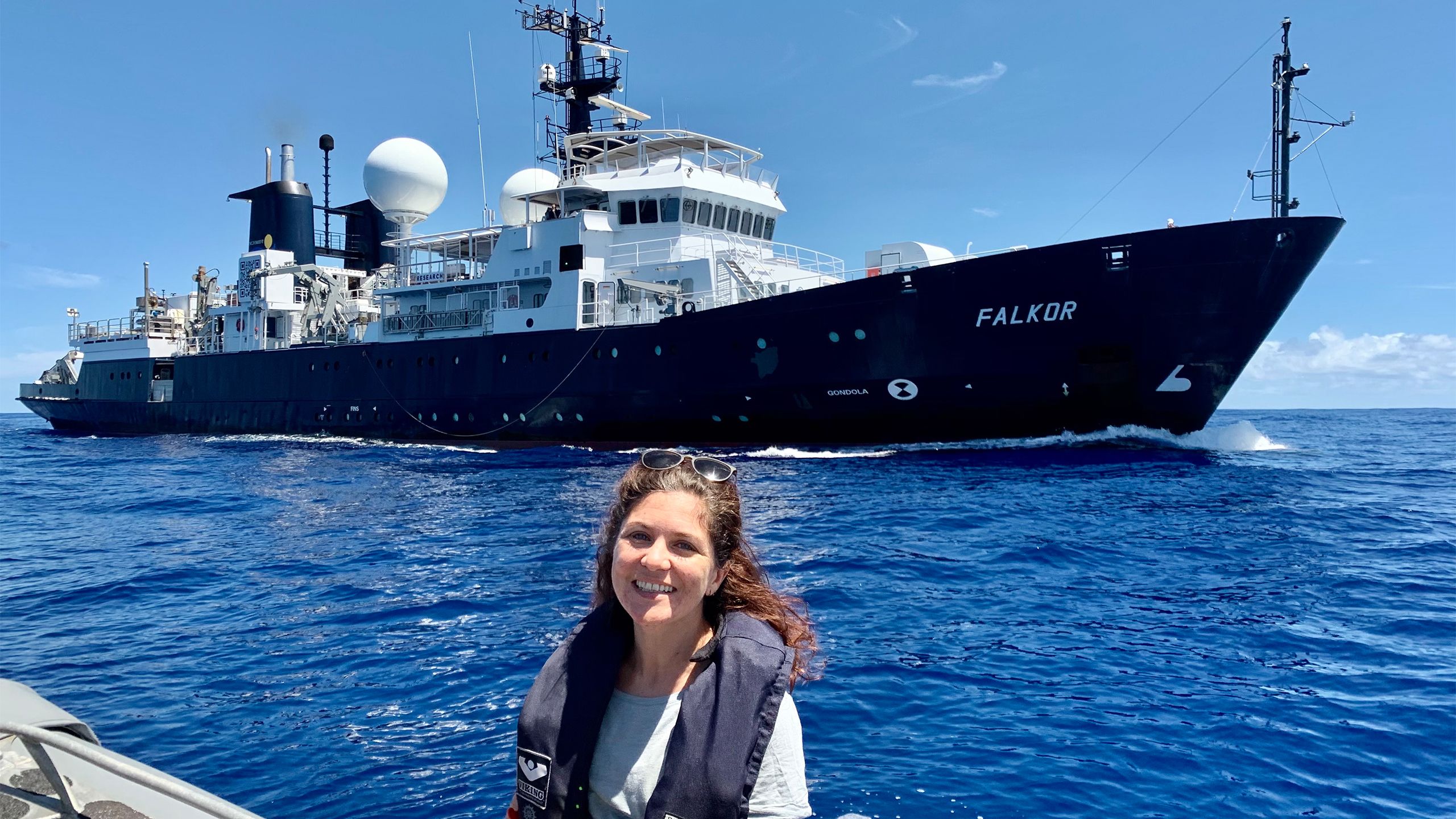 Dr Gürer with the research boat, Falkor in the background.