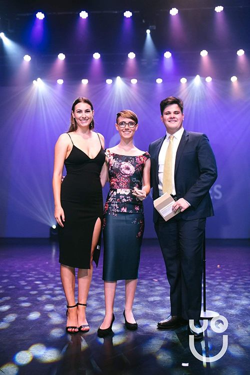 Mx Bradford (centre) accepting the UQ Union "Clubbies" award for the 2019 Event Series of the Year on behalf of the UQ Drawing Club