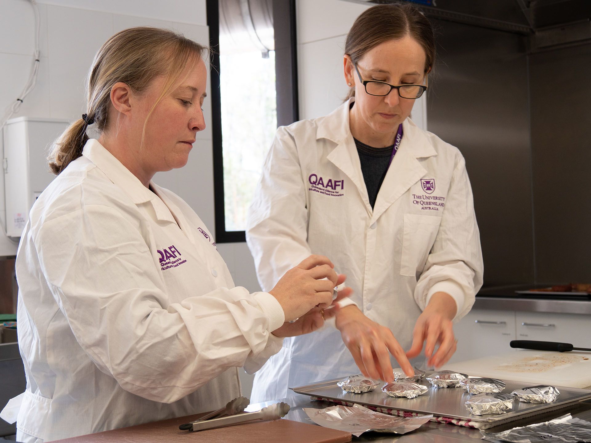 Associate Professor Heather Smyth and fellow researcher preparing samples in sensory laboratory wearing white lab coats