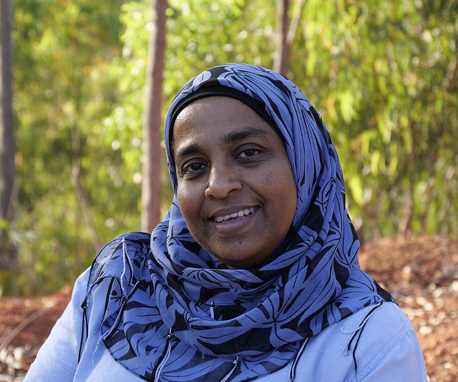 Professor Yasmina Sultanbawa standing in an outdoor setting, smiling at the camera