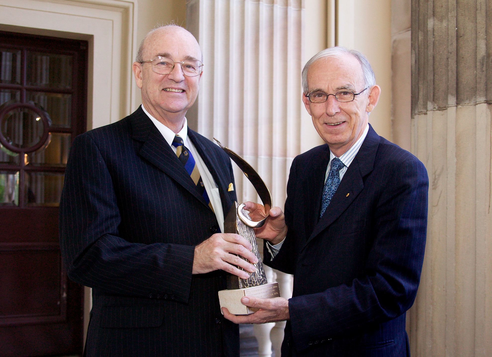 Professor John Pearn with Sir Llew Edwards holding an award