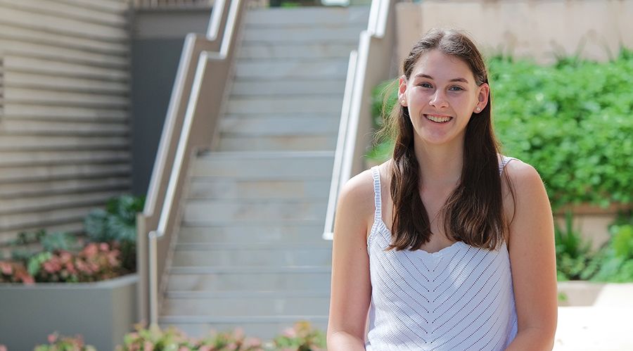 A young woman with brown hair smiling at the camera