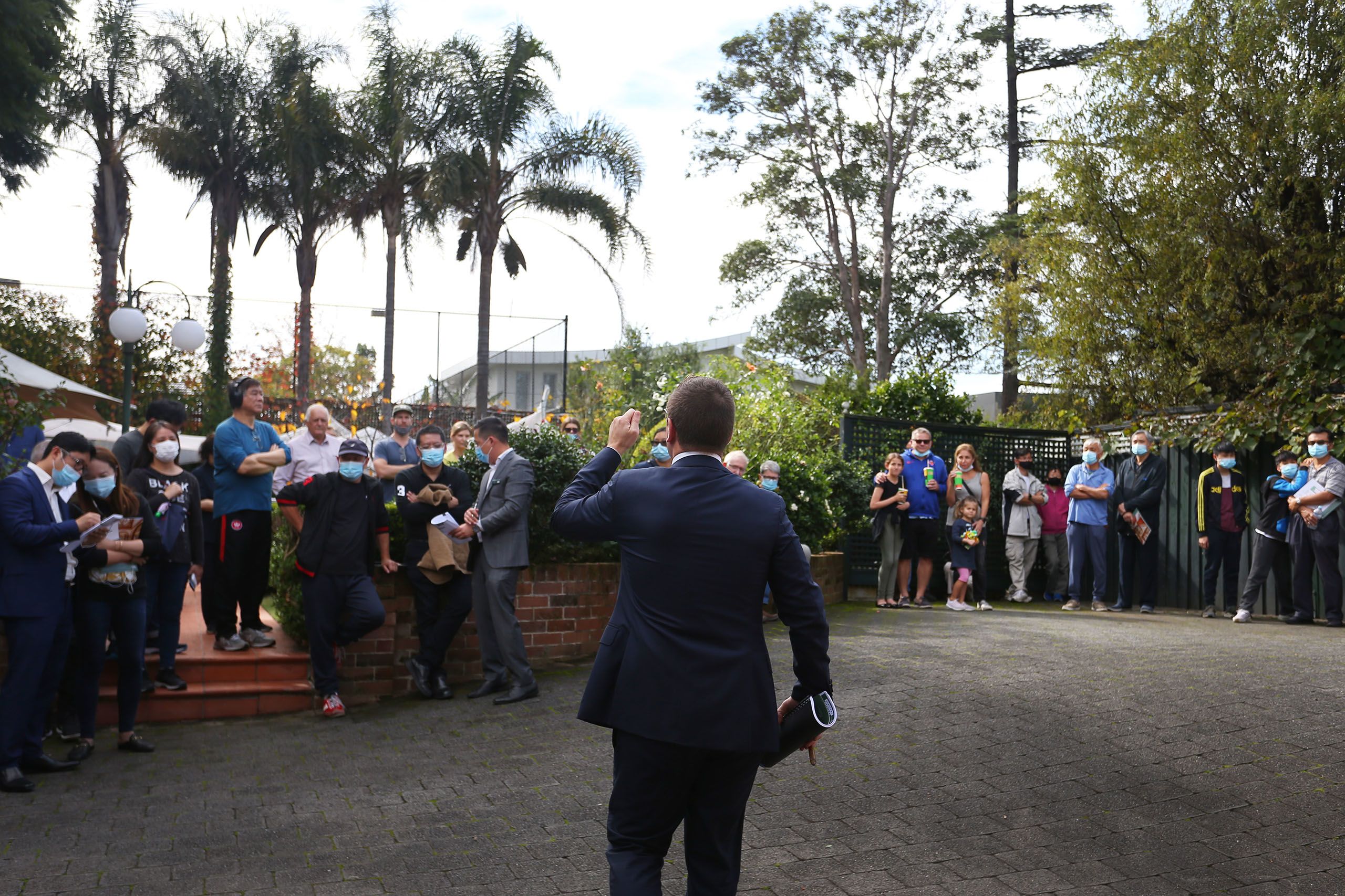 An auctioneer at a house auction, taken from behind the auctioneer
