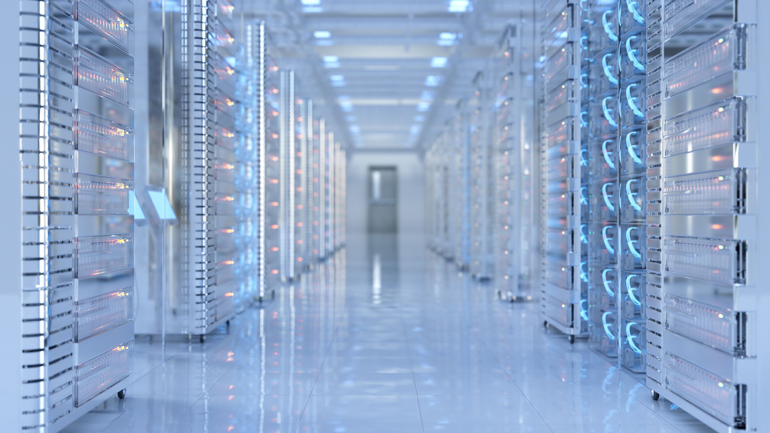 A data centre with a white tiled floor, white walls and tall racks of telecommunications equipment. The room is dimly lit with the pale blue glow that is emanating from the equipment.