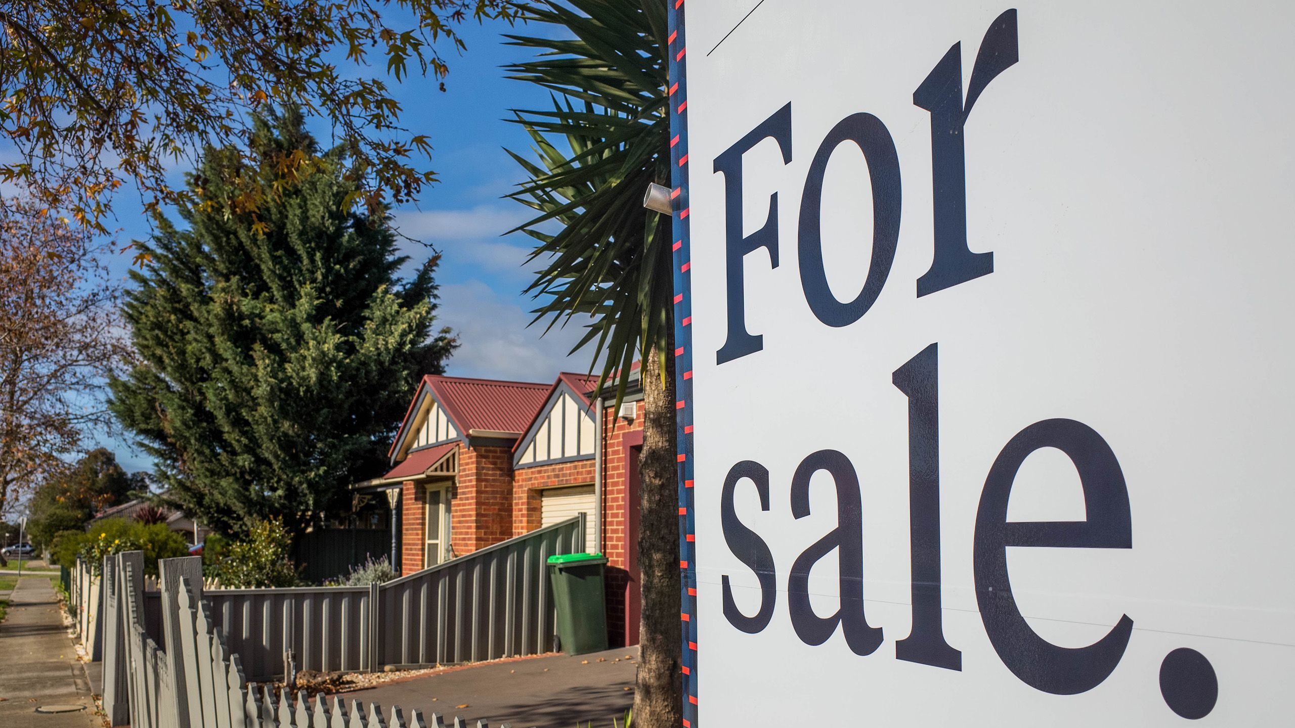 A 'For Sale' sign outside of a house in an Australian suburb