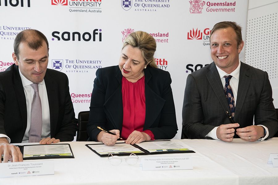 Sanofi's Jean-Francis Toussaint, Deputy Premier Annastacia Palaszczuk and Deputy Premier Steven Miles sitting at a table signing a document.