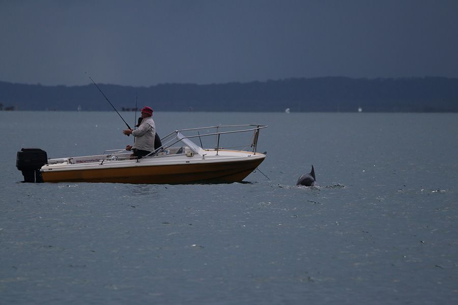 A person fishing from a small boat in the ocean