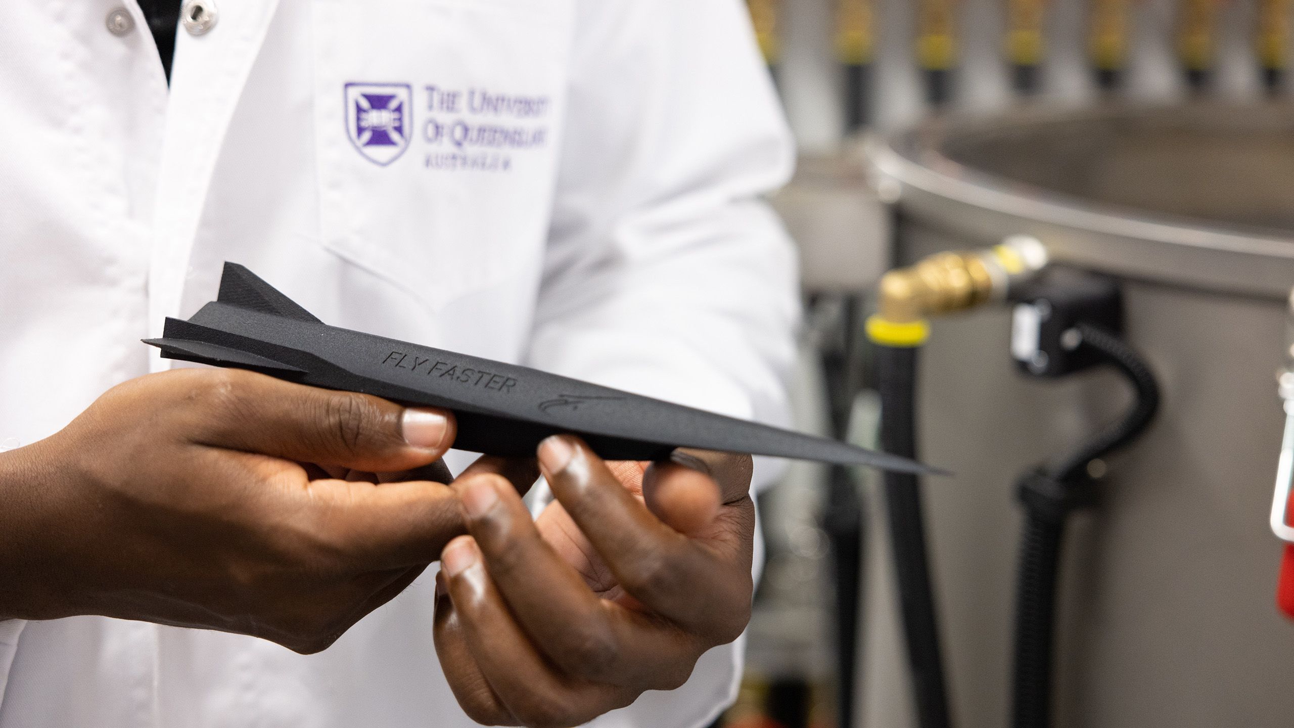 A close up of a person's hands holding a three-dimensional model of a hypersonic jet