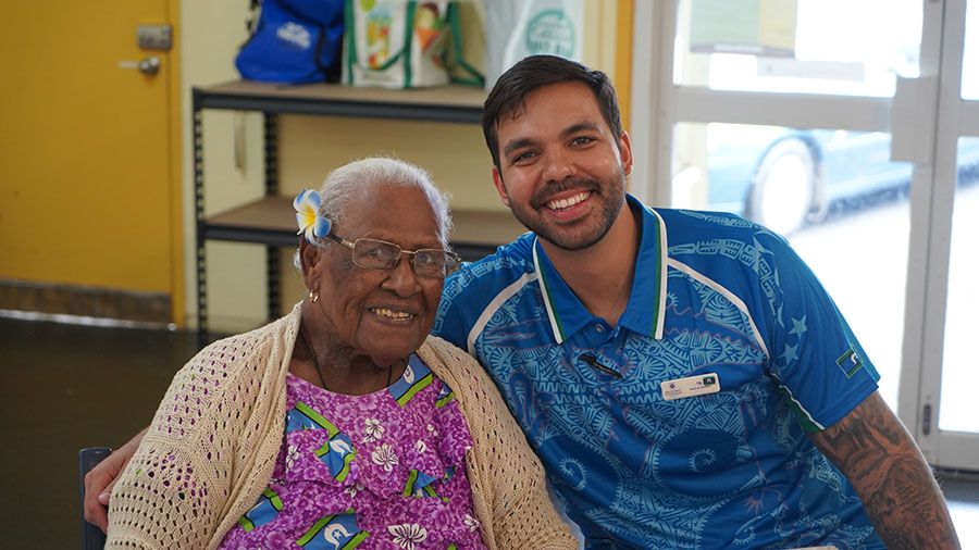 An elderly woman and a young man smiling at the 