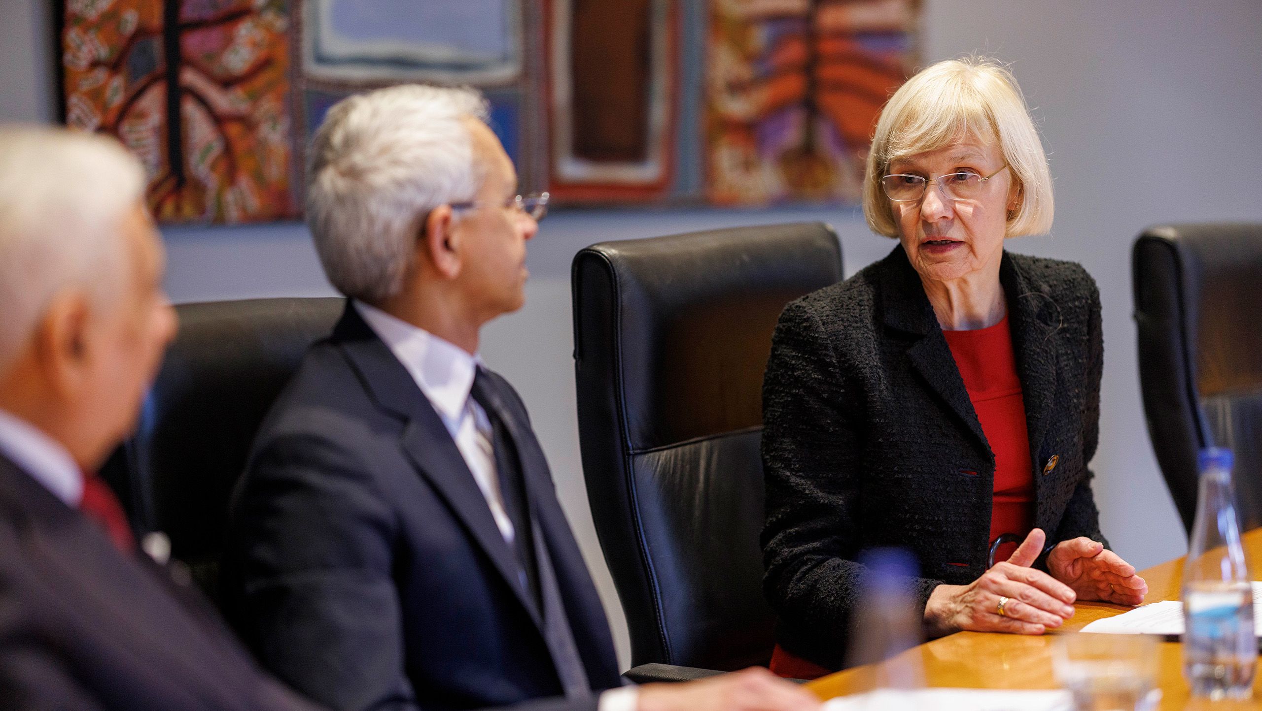 Three people, including UQ Vice-Chancellor Professor Deborah Terry, meeting at a table in a boardroom
