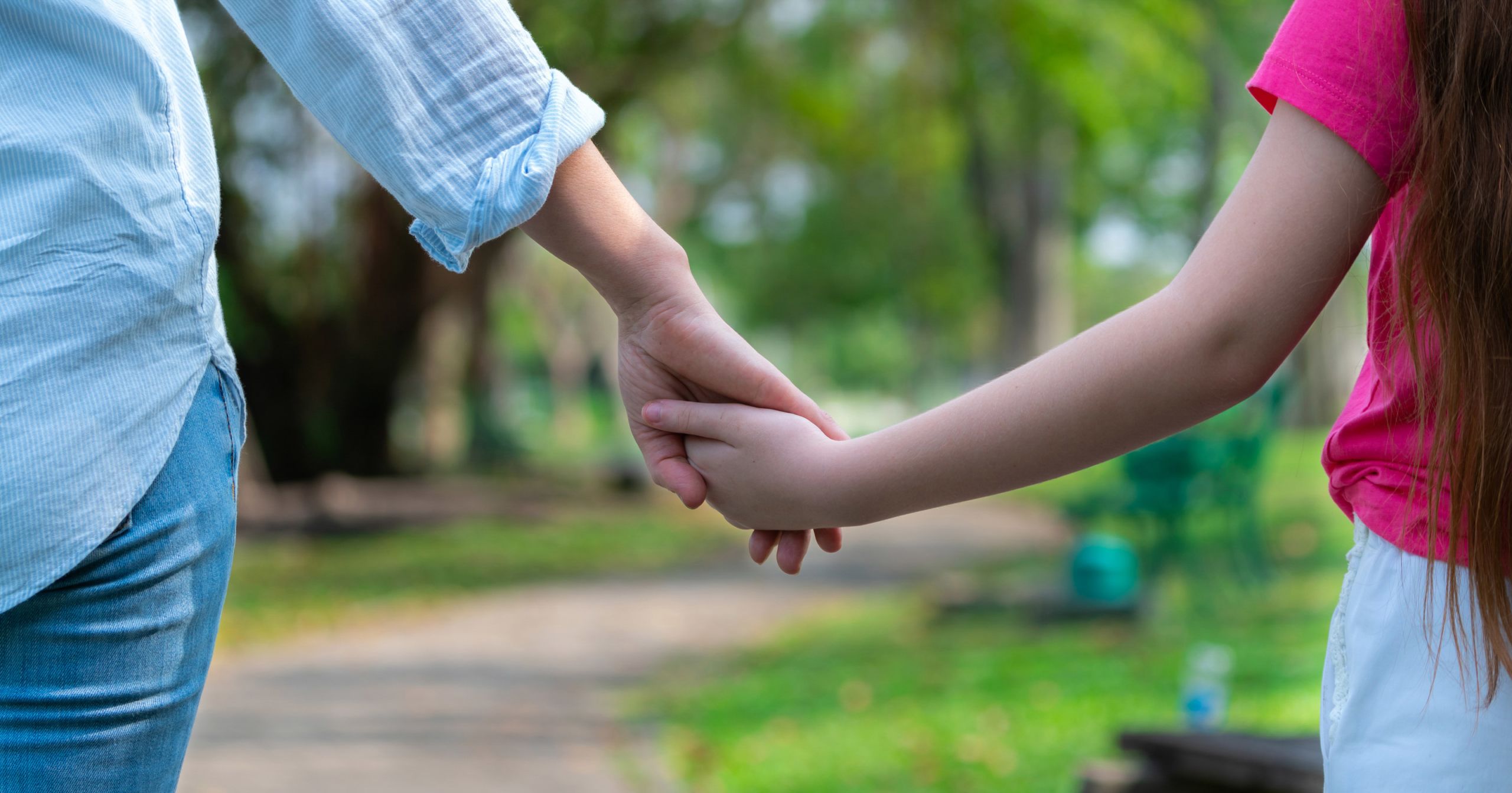 A girl holding a woman's hand.