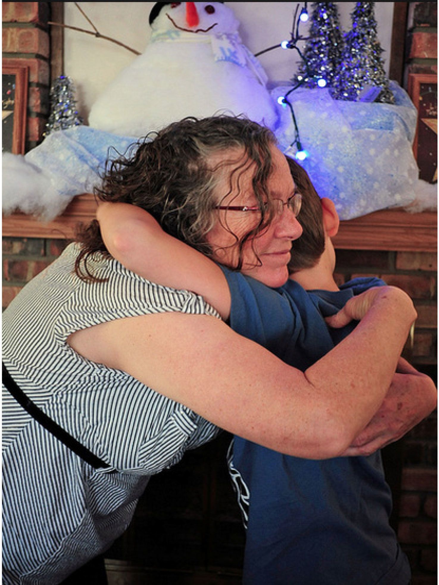 A woman hugs her grandson.