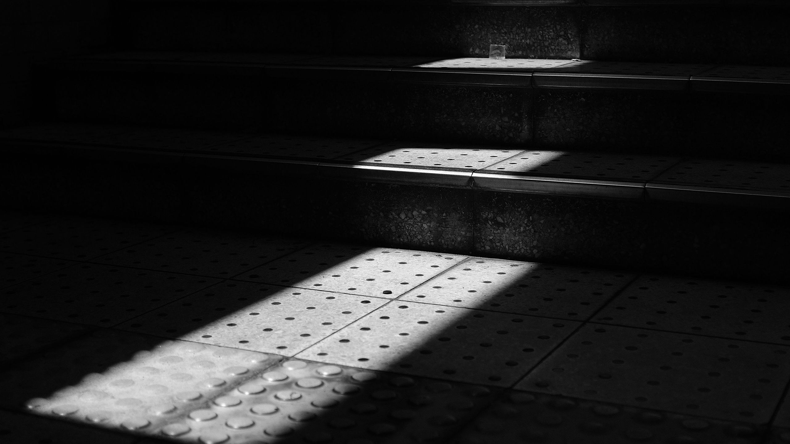 An image of a light shining on sections of a dark stairwell.