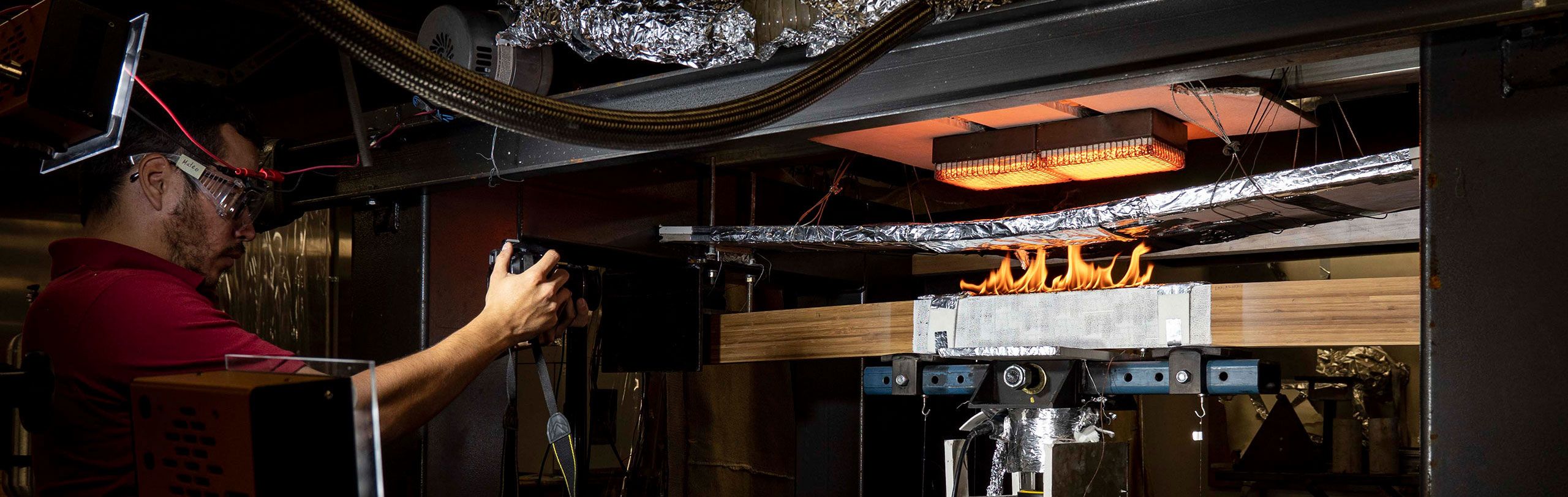 An image of UQ Research Scholar Mateo Gutierrez testing materials at UQ's Fire Lab.