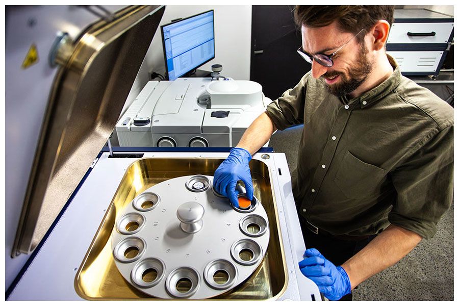 A male student smiles while testing materials in UQ's fire safety engineering testing facility.