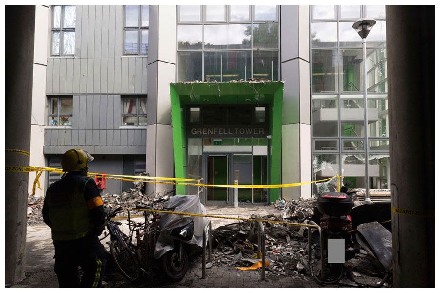 A fireman stands next to wreckage at the entrance to Grenfell Tower after the tragedy.