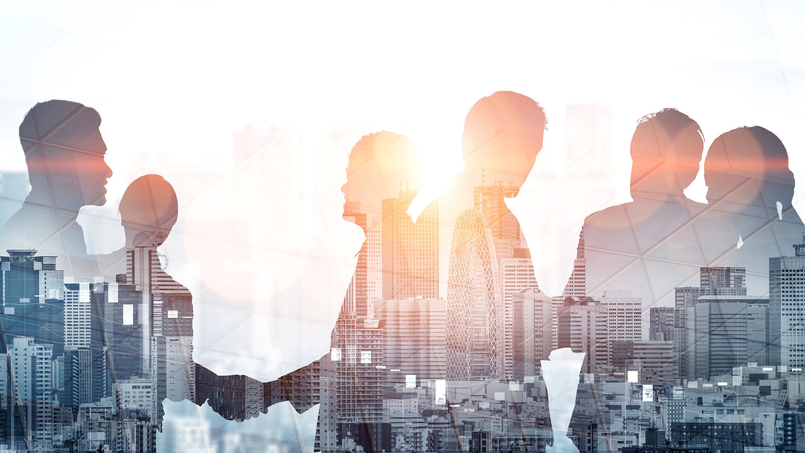 Silhouettes of six people shaking hands superimposed over a photograph of tall buildings in a city
