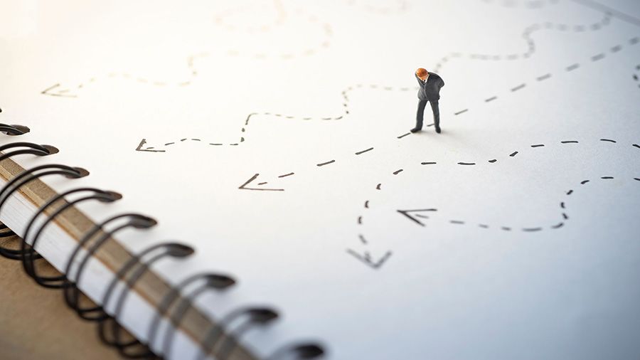 A small figure standing on the page of a notebook and looking down at a dotted-line arrow