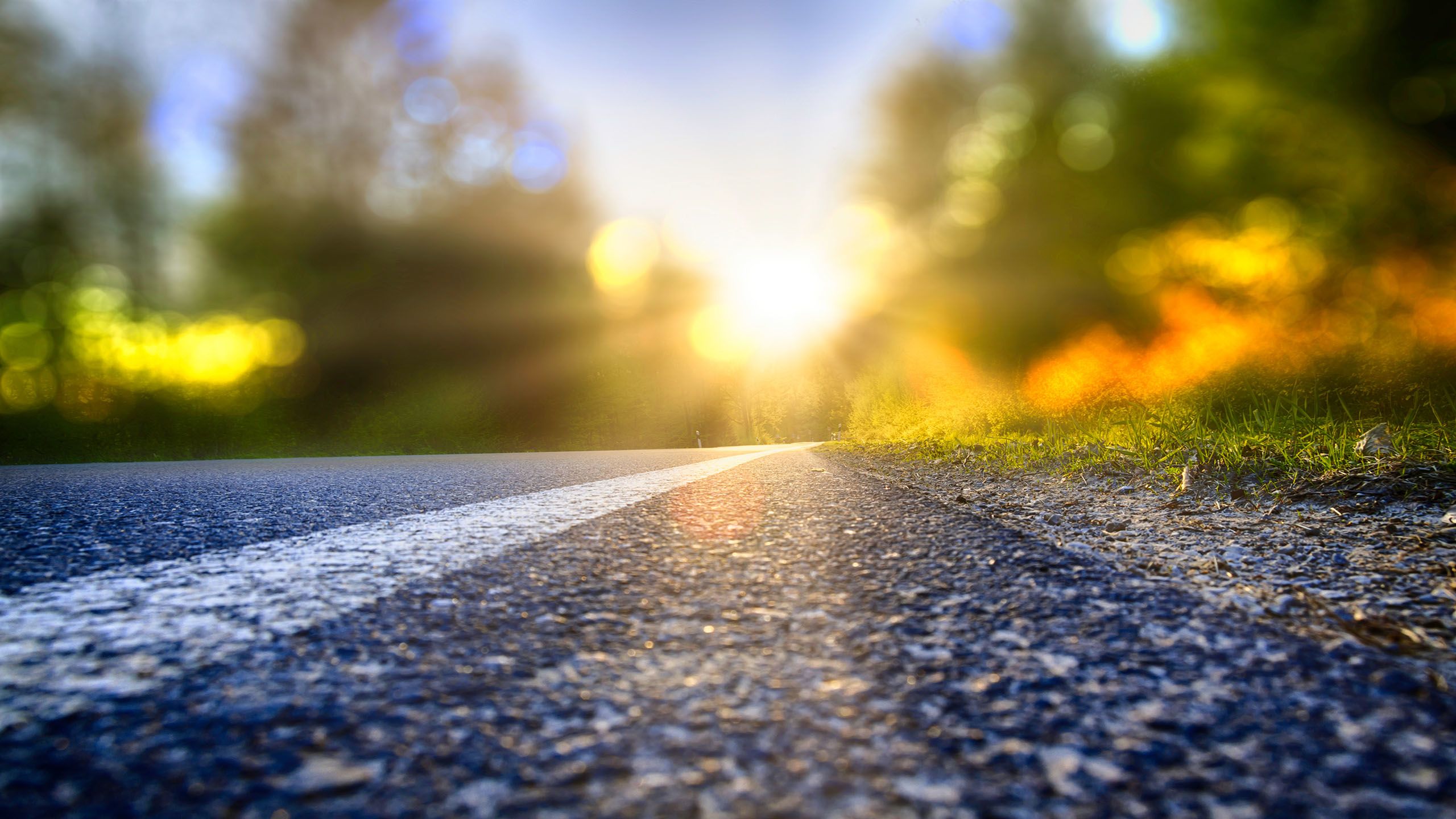 The right-hand side of a road with sunlight reflecting off it