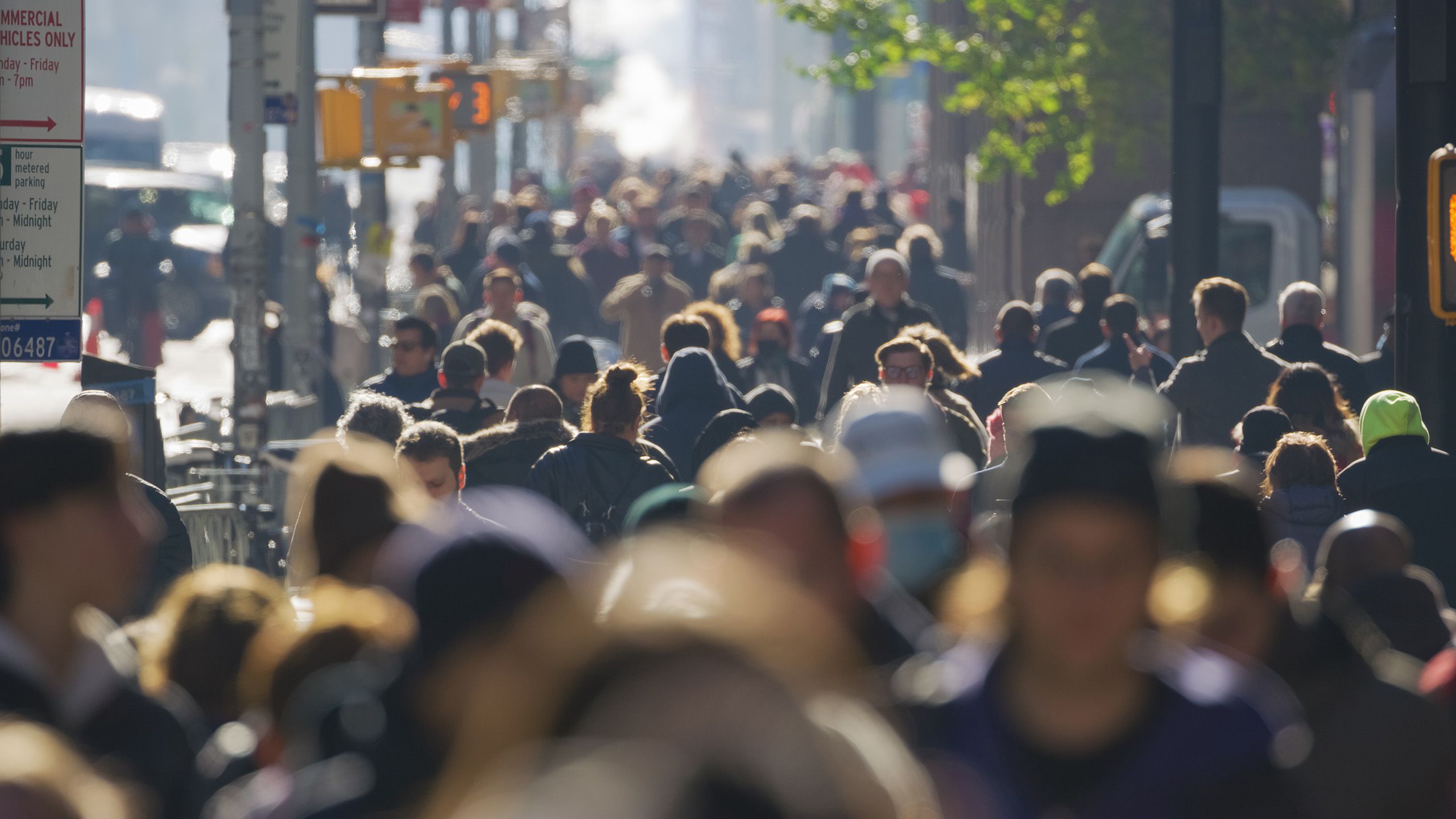 A busy footpath beside a road in a city.