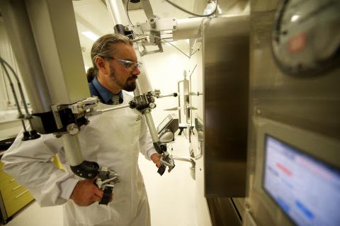 UQ research radiochemist Damion Stimson operates the tele-manipulators in one of the hot cells at the radiochemistry suite.
