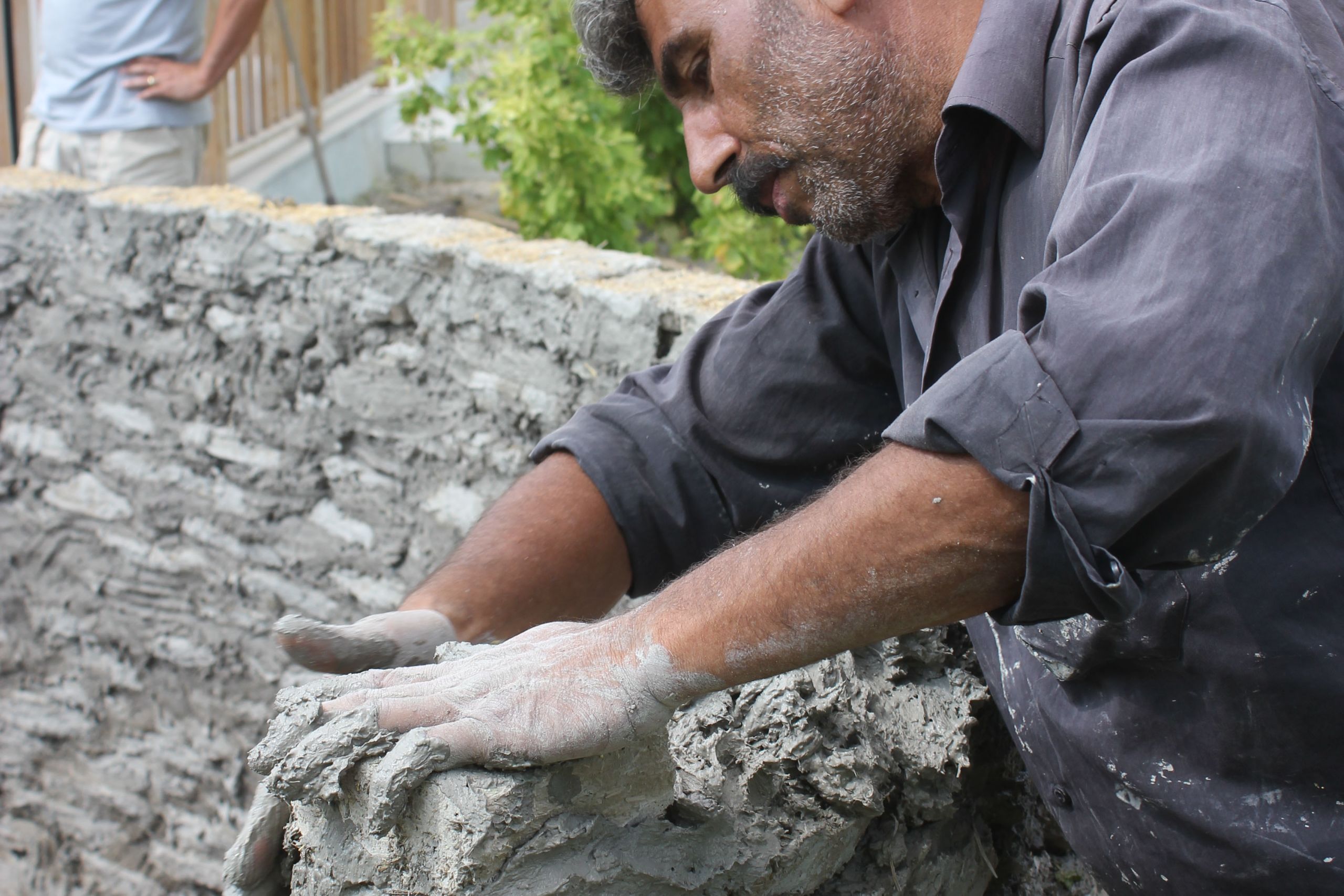 Turkish man building mud brick hut with his hands