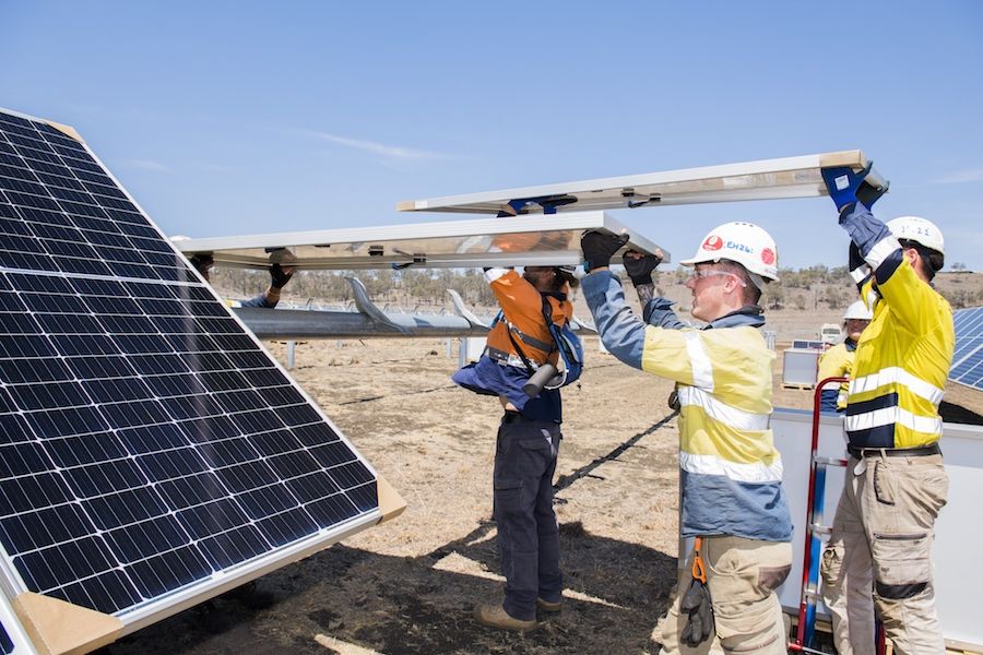 Workers installing a solar panel at UQ's Warwick Solar Farm.