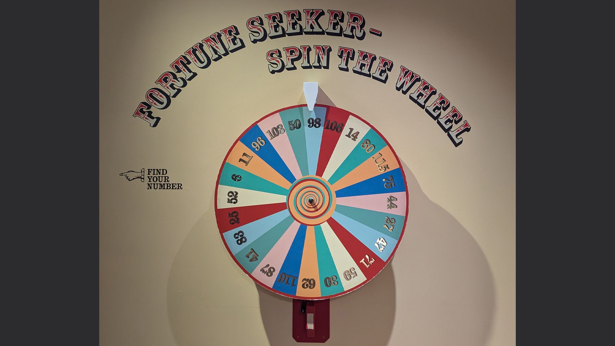 Image of a spining wheel with lots of coloured numbers and the title 'fortune seeker - spin the wheel'