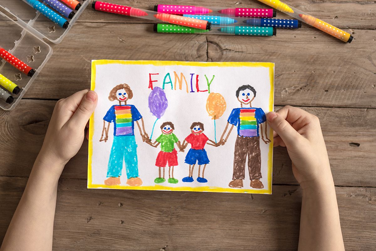 A children's drawing of a family. The parent's are wearing rainbow t-shirts.