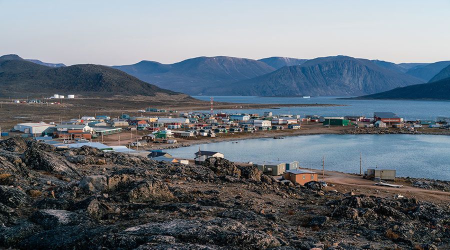 Dusk in a harsh arctic landscape with bare hills and ocean. Overlook of Inuit settlement of Qikiqtarjuaq, Broughton Island, Nunavut