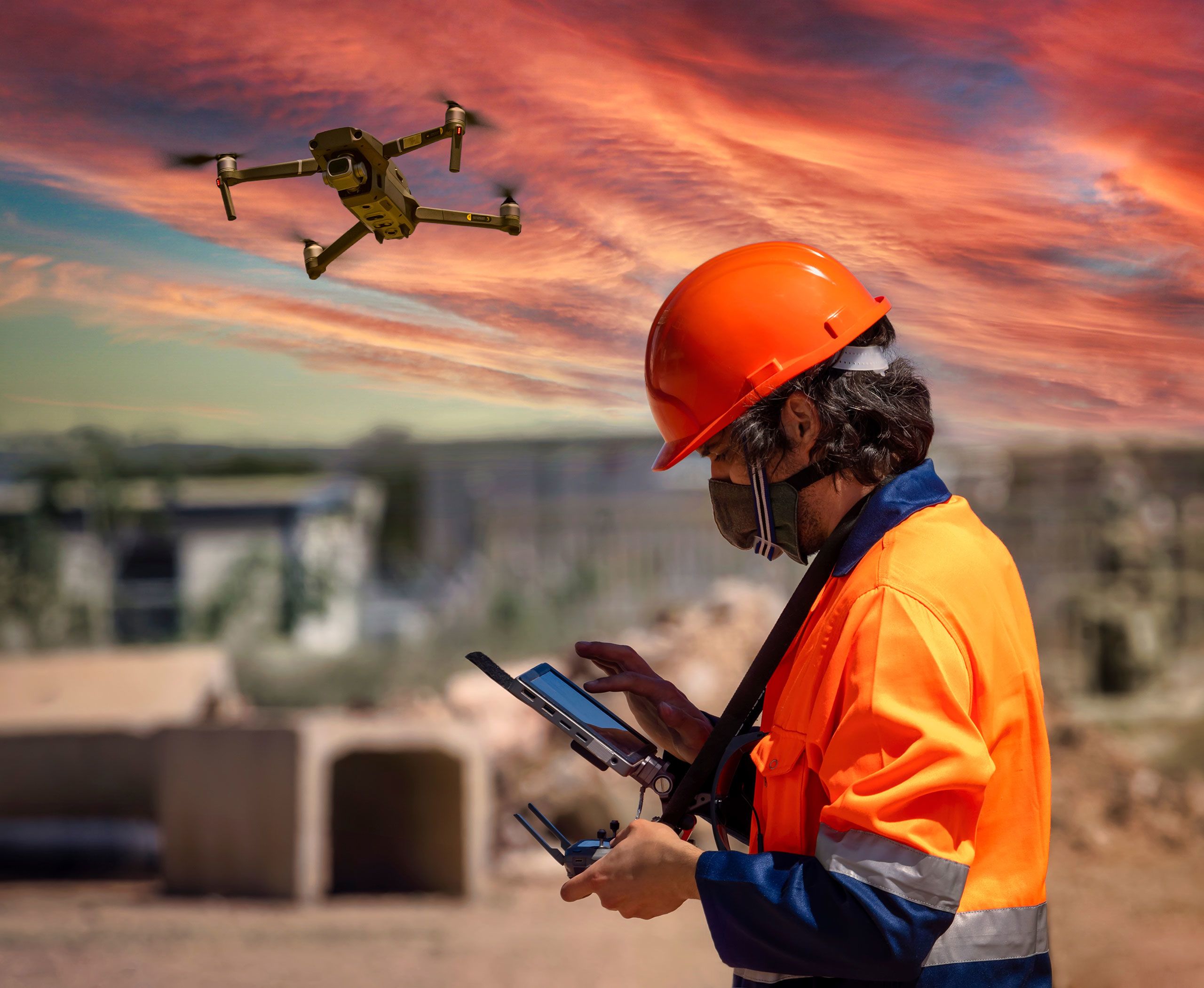 Drone pilot in PPE clothing operating a drone