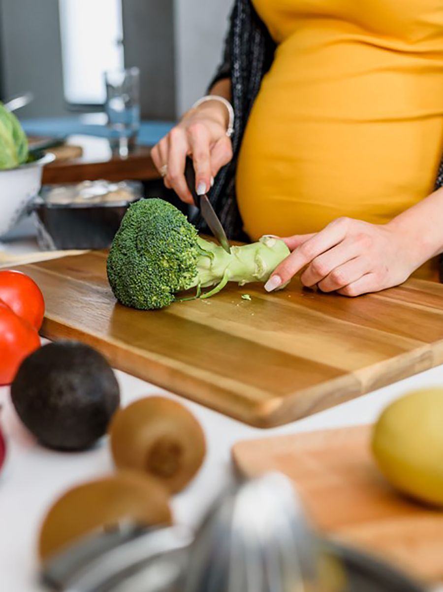 Pregnant woman cutting vegetables