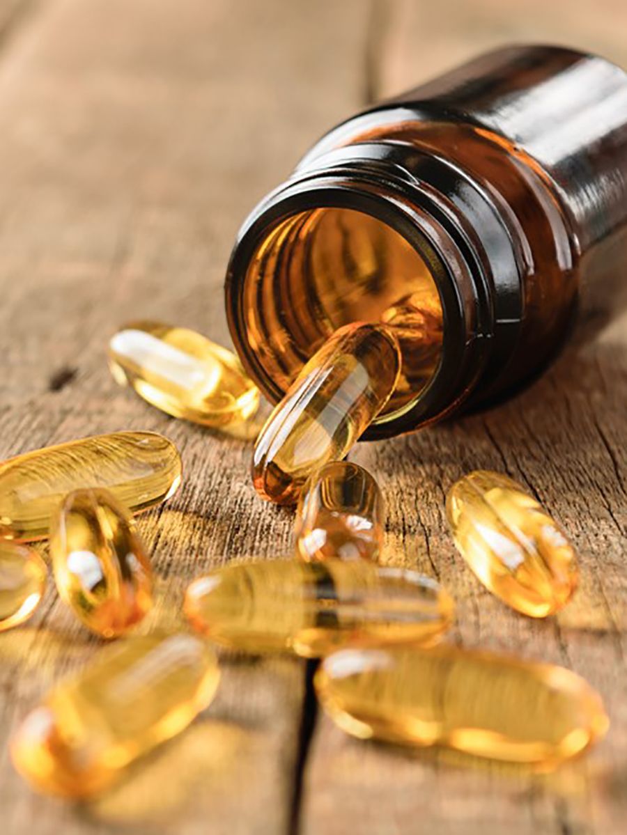 Vitamin D tablets spilling from a pill bottle on a table
