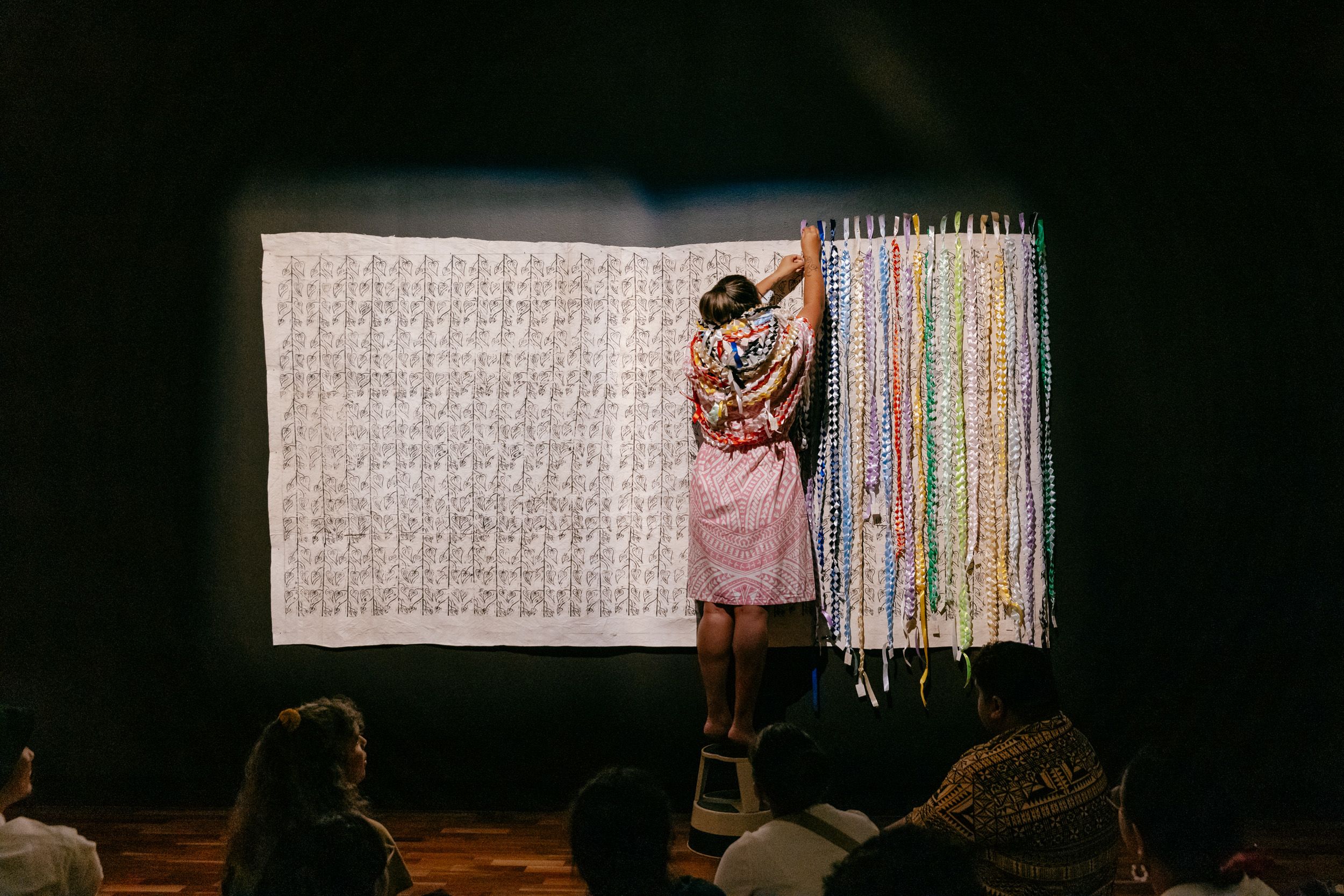 Artist Cora-Allan performing in front of her artwork 'Let these vines hold you' at UQ Art Museum.