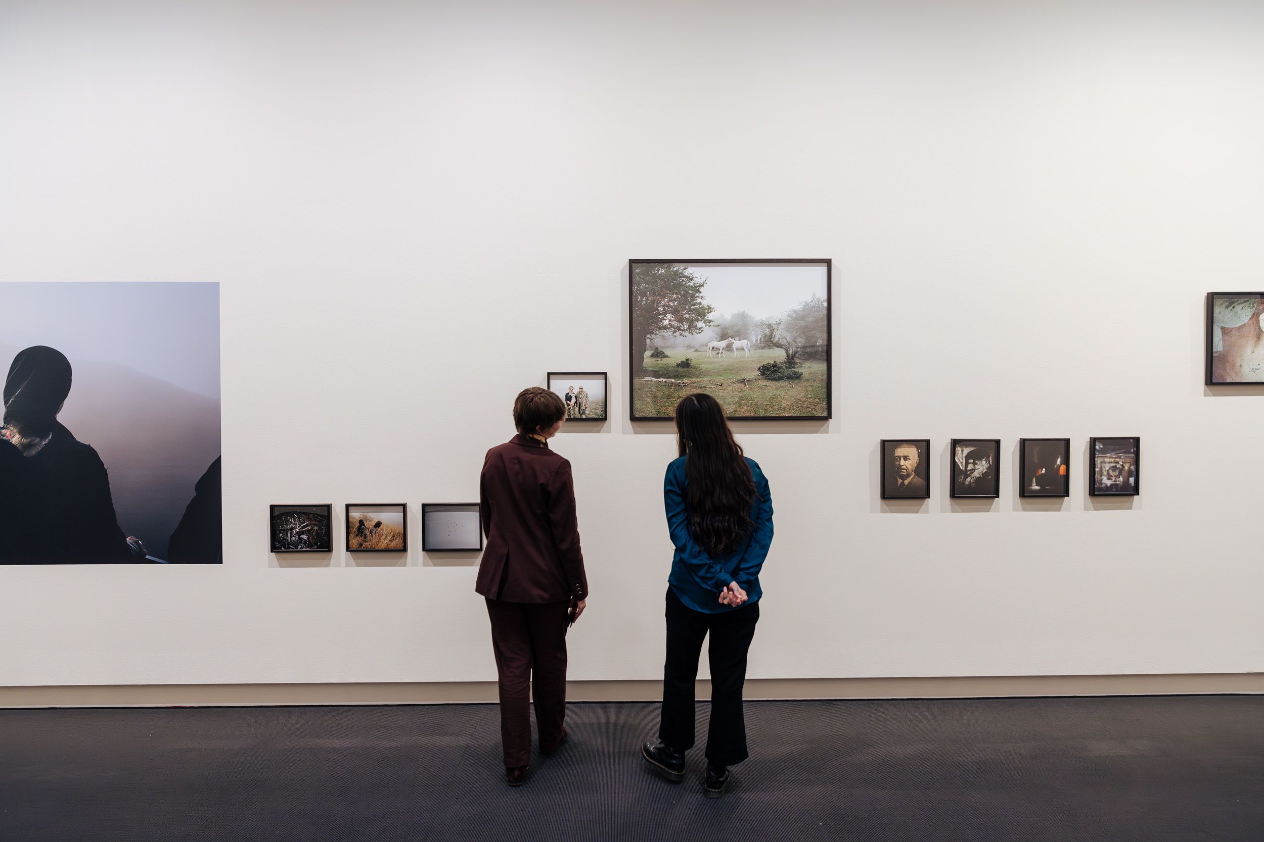 Two people viewing photographs by artist Hoda Afshar in UQ Art Museum.