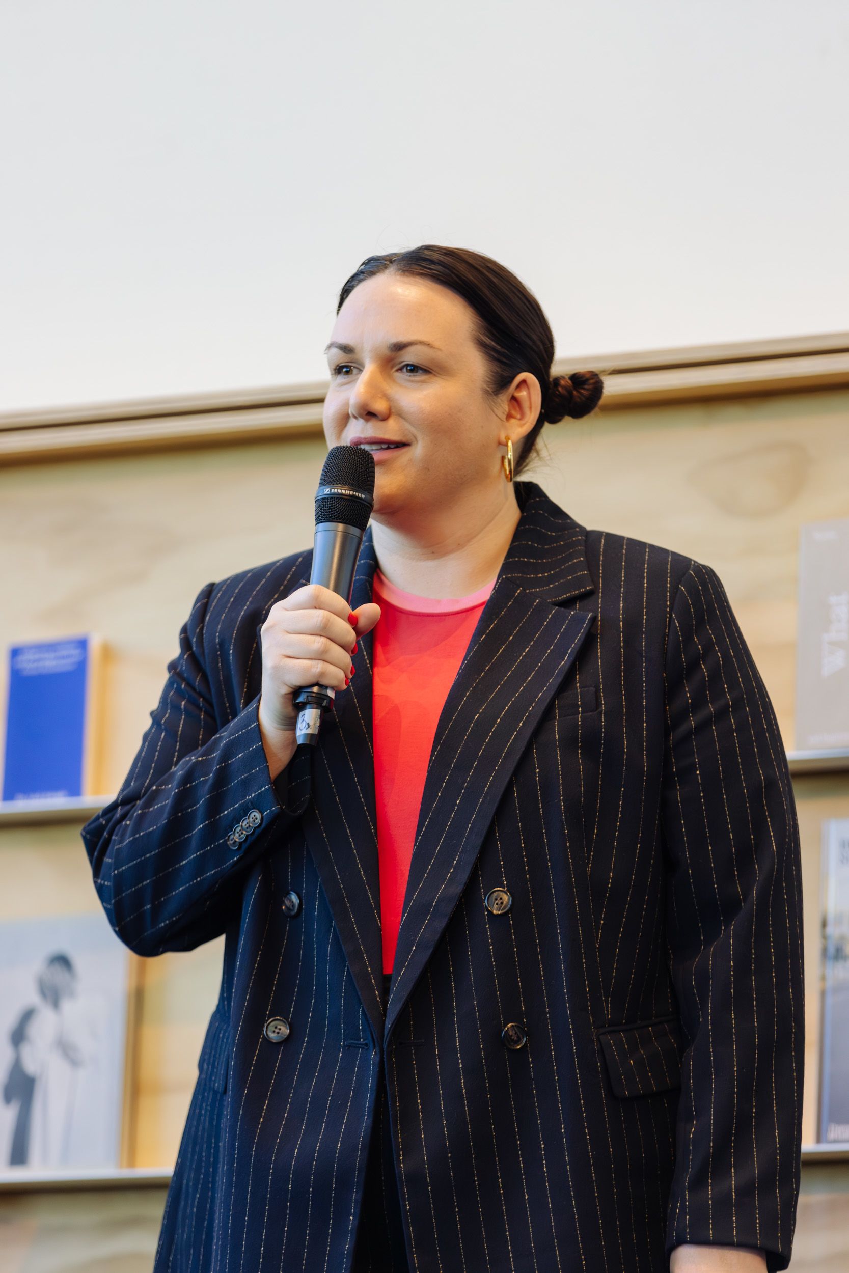 UQ Art Museum Director Peta Rake smiling and talking into a microphone.